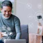 Homem de frente ao notebook, com icones demonstrando a estratégia omnichannel