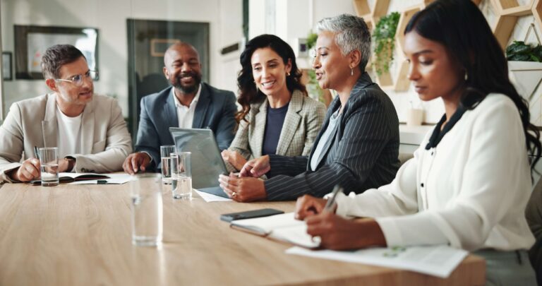 Reunião de equipe discutindo estratégias de JBP (Joint Business Plan), com profissionais diversos colaborando em um ambiente corporativo moderno e colaborativo