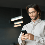 Homem com celular em mãos. representando o uso de aplicativo de conversa