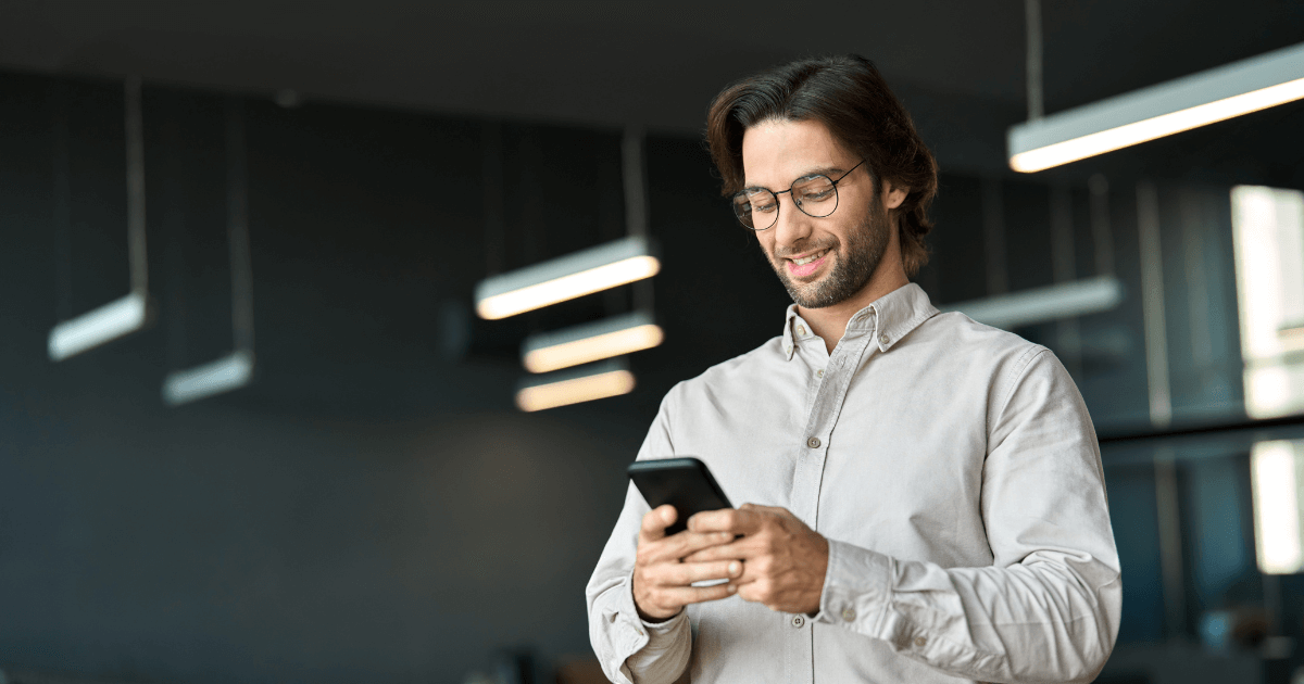 Homem com celular em mãos. representando o uso de aplicativo de conversa