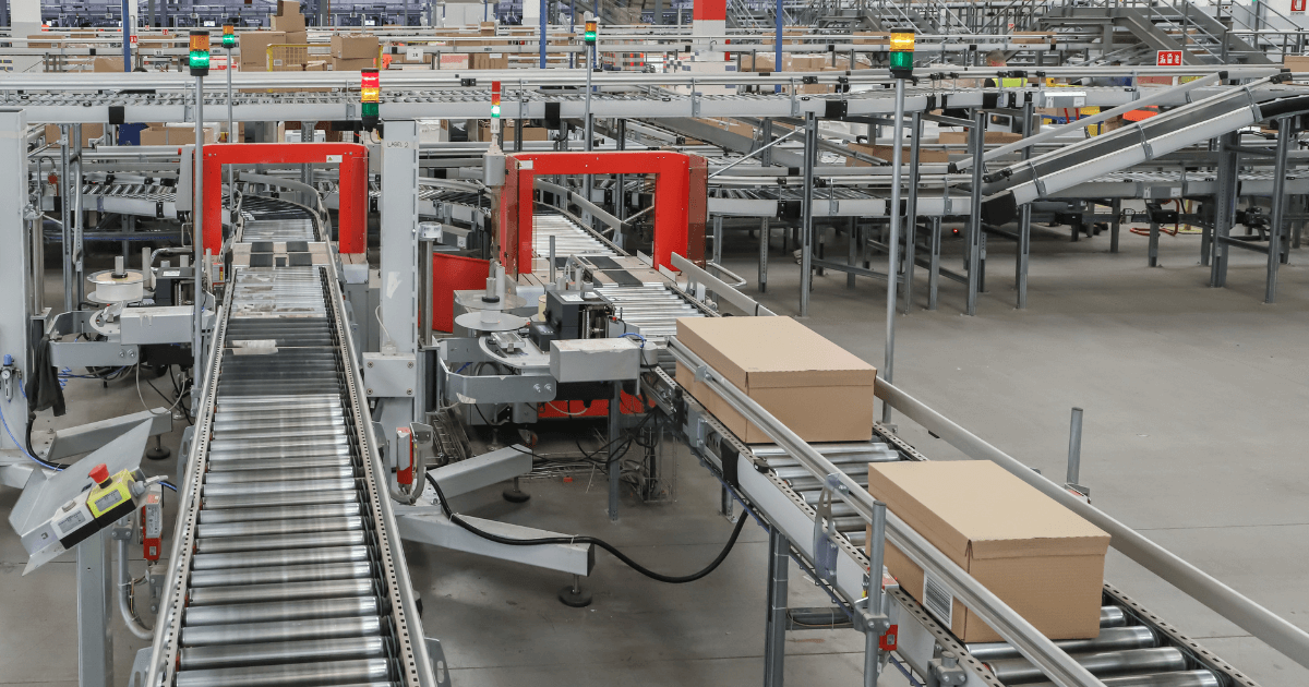 Esteira automatizada transportando caixas em centro de distribuição, ilustrando os benefícios da automação logística na eficiência operacional das empresas.