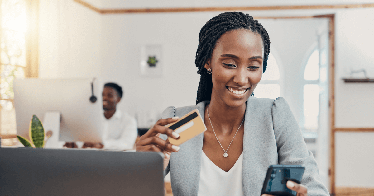 Profissional utilizando celular para realizar pagamento com cartão corporativo, ilustrando a gestão de despesas empresariais e benefícios desse tipo de cartão.