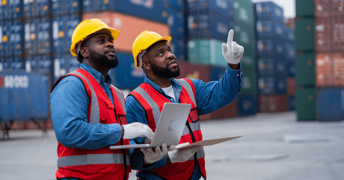 Profissionais de logística analisando containers em porto, representando o papel do freight forwarder na gestão eficiente da cadeia internacional com apoio de ERP.