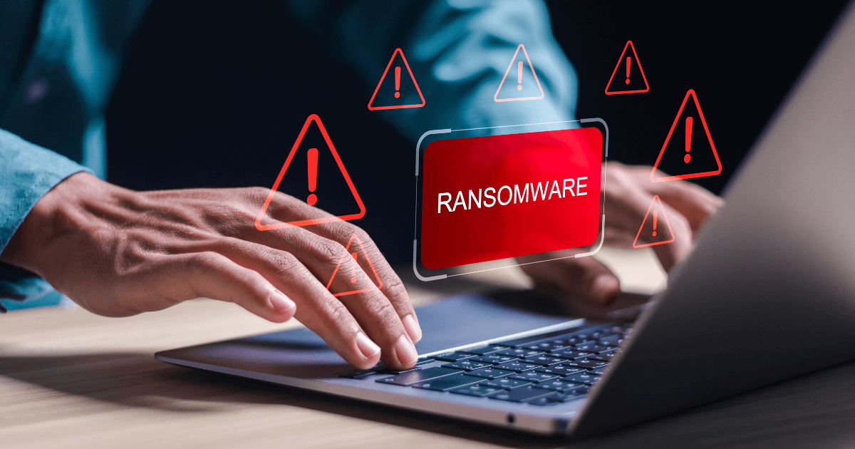 Alerta de ransomware na tela de um notebook, representando ataque cibernético e riscos à segurança de dados empresariais.